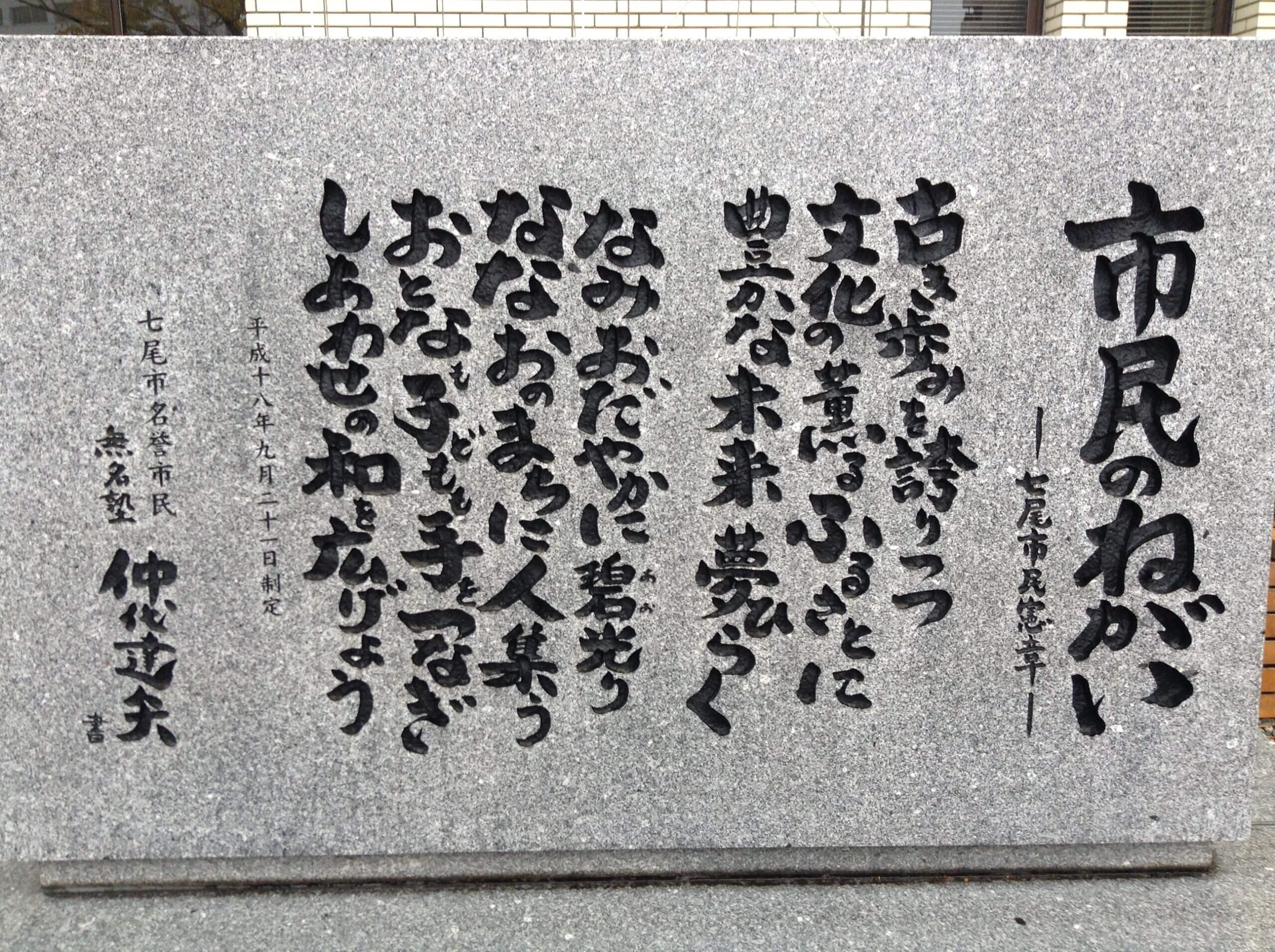 七尾市役所前にある七尾市民憲章石碑の文字は仲代達矢氏の書